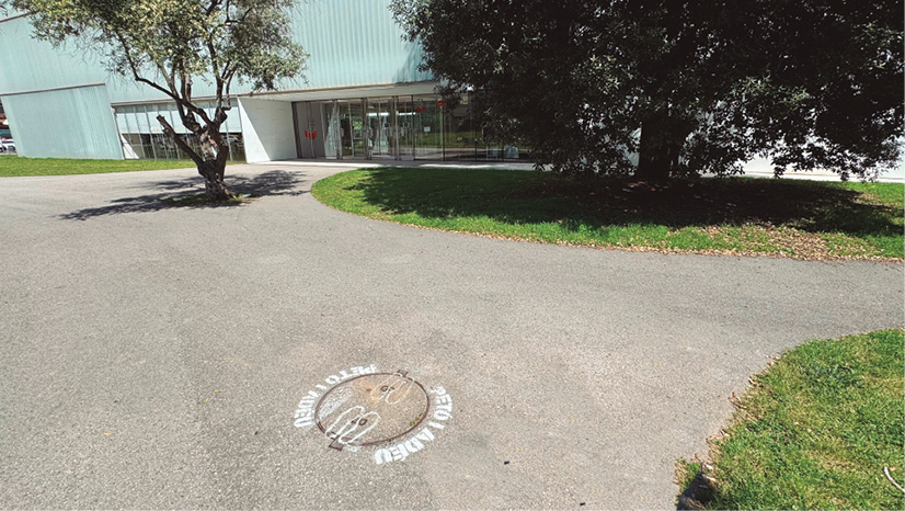 A manhole cover in a driveway

Description automatically generated